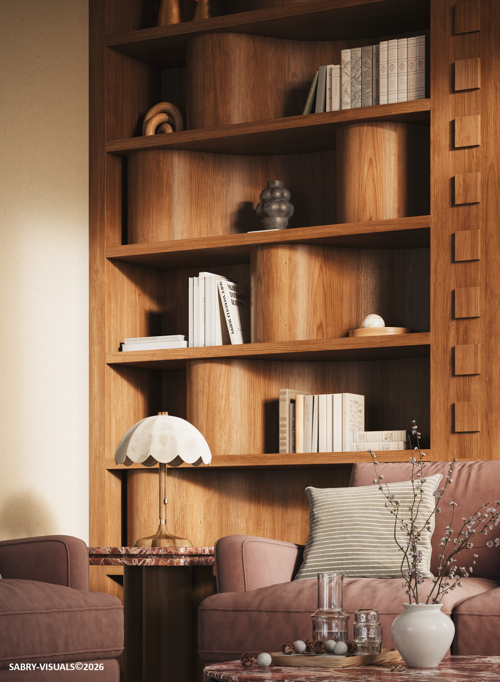 Curved walnut shelving with books and ceramics above a pink sofa and a scalloped table lamp